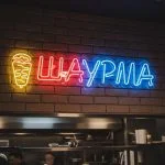 Неоновая вывеска «ШАУРМА» с жёлто-красно-синей подсветкой для кафе