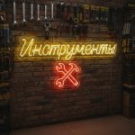 Неоновая вывеска «ИНСТРУМЕНТЫ» с ключами и жёлто-красной подсветкой