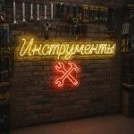 Неоновая вывеска «ИНСТРУМЕНТЫ» с ключами и жёлто-красной подсветкой