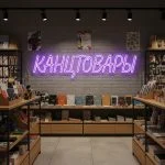 Неоновая вывеска «КАНЦТОВАРЫ» с сиреневой подсветкой