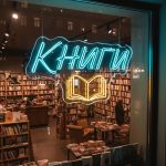 Неоновая вывеска «КНИГИ» с голубо-жёлтой подсветкой и контуром открытой книги