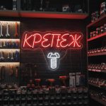 Неоновая вывеска «КРЕПЁЖ» с бело-красной подсветкой и изображением самореза