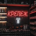 Неоновая вывеска «КРЕПЁЖ» с бело-красной подсветкой и изображением самореза