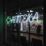Неоновая вывеска «АПТЕКА» с зелёным крестом и белой подсветкой